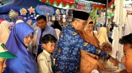 Pengawas SD Wilayah Kota Pamekasan, Nurul Huda didampingi Kepala SDI Al-Munawarah Pamekasan, Ustadzah Dedeh Rosidah mengunjungi stand bazar siswa. (DOK. KLIKMADURA)