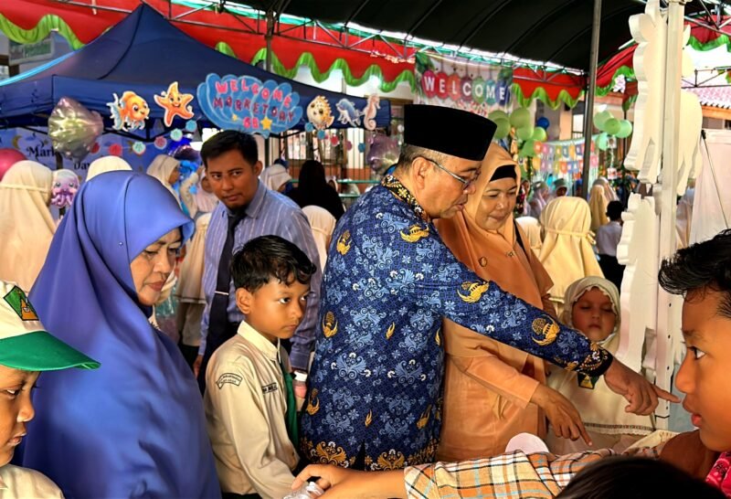 Pengawas SD Wilayah Kota Pamekasan, Nurul Huda didampingi Kepala SDI Al-Munawarah Pamekasan, Ustadzah Dedeh Rosidah mengunjungi stand bazar siswa. (DOK. KLIKMADURA)