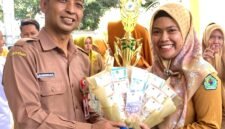 Kepala Dinkes Pamekasan dr. Saifudin menyerahkan hadiah kepada Kepala Puskesmas Pademawu dr. Jeni Novita Anggraini. (DOK. KLIKMADURA)