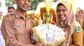 Kepala Dinkes Pamekasan dr. Saifudin menyerahkan hadiah kepada Kepala Puskesmas Pademawu dr. Jeni Novita Anggraini. (DOK. KLIKMADURA)