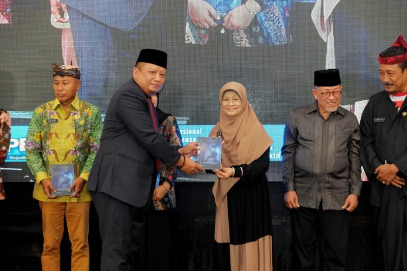 Dirut PT. Royal Madura Media Kita, H. Muhammad Mukid menyerahkan buku kepada psikolog Elly Risman pada kegiatan Gebyar Pendidikan di Ballroom Azana Style Pamekasan. (DOK. SINAR MULYA)