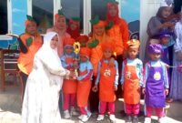 Kepala TK Plus Assyafiiyah, Nyai Hj. Hafsah Masduqie menyerahkan hadiah kepada pemenang Market Day. (SARI PURWATI / KLIKMADURA)