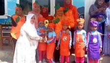 Kepala TK Plus Assyafiiyah, Nyai Hj. Hafsah Masduqie menyerahkan hadiah kepada pemenang Market Day. (SARI PURWATI / KLIKMADURA)