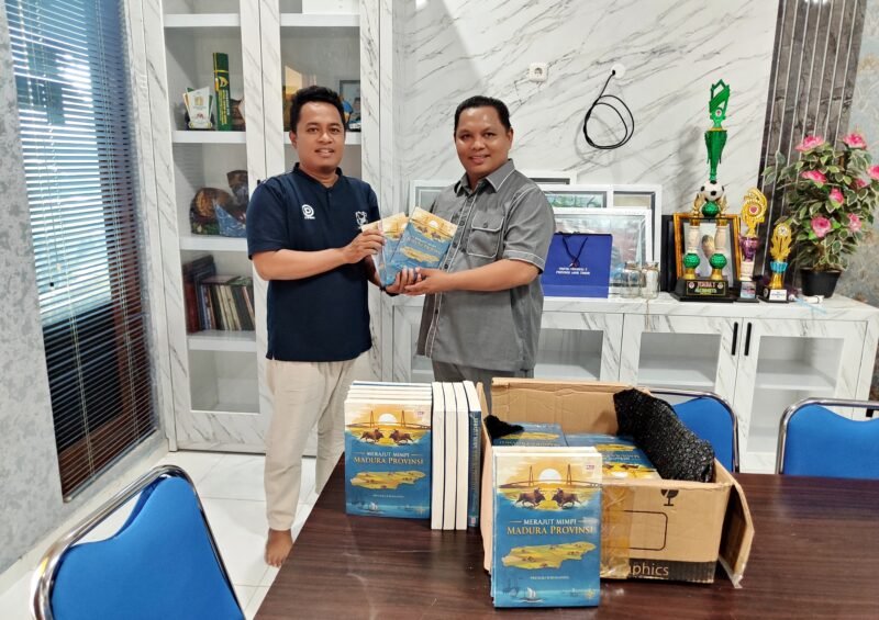 Penulis buku Merajut Mimpi Madura Provinsi, Prengki Wirananda (kiri) menyerahkan hasil karyanya kepada Wakil Ketua DPRD Pamekasan, Ismail. (ISTIMEWA)