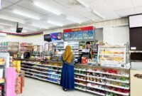 Kasir Indomaret di Jalan Pintu Gerbang, Kelurahan Bugih, Pamekasan melayani pembeli. (LAILIYATUN NURIYAH/KLIK MADURA)