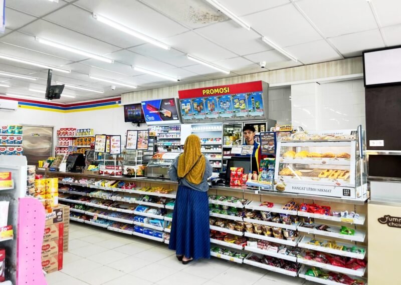 Kasir Indomaret di Jalan Pintu Gerbang, Kelurahan Bugih, Pamekasan melayani pembeli. (LAILIYATUN NURIYAH/KLIK MADURA)