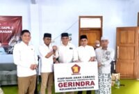 Ketua DPD Gerindra Pamekasan, Kusriyanto (pakai kacamata) menyerahkan plakat kepada Syaiful Yadi usai pelantikan. (KLIKMADURA)