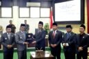 Ketua DPRD Pamekasan, Ali Masykur menyerhakan berkas APBD 2026 kepada Bupati Dr. KH. Kholilurrahaman usai rapat paripurna. (KLIKMADURA)