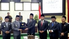 Ketua DPRD Pamekasan, Ali Masykur menyerhakan berkas APBD 2026 kepada Bupati Dr. KH. Kholilurrahaman usai rapat paripurna. (KLIKMADURA)
