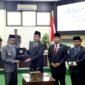 Ketua DPRD Pamekasan, Ali Masykur menyerhakan berkas APBD 2026 kepada Bupati Dr. KH. Kholilurrahaman usai rapat paripurna. (KLIKMADURA)