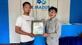 Jurnalis Klik Madura, Moh. Iqbalul Khavei MZ (kanan) menyerahkan cinderamata berupa emas batangan kepada Ketua JCP, Achmad Jaddid. (KLIKMADURA)