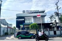 Warga melintas di depan Kantor BPJS Kesehatan Cabang Pamekasan. (MOH. IQBALUL KHAVEI MZ / KLIKMADURA)