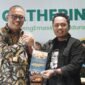 Deputi Bisnis PT Pegadaian Syariah Area Madura, Anwar Hidayat menerima cinderamata berupa buku berjudul Merajut Mimpi Madura Provinsi karya Pemred Klik Madura, Prengki Wirananda di akhir kegiatan Media Gathering. (YUSRIL RAHMAN SYAKUR / KLIKMADURA)