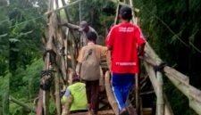 Siswa SDN Palengaan Daja 1 melintasi jembatan dari bambu menuju sekolahnya. (KLIKMADURA)