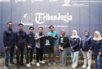 Pemred Klik Madura, Prengki Wirananda menyerahkan kaus kepada Manajer Digital Tribun Jogja, Ikrob Didik Irawan. (KLIKMADURA)