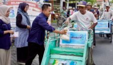 Pemred Klik Madura, Prengki Wirananda membagikan sembako kepada abang becak pada perayaan HUT ke-3 Klik Madura. (YUSRIL RAHMAN SYAKUR / KLIKMADURA)