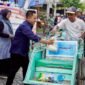 Pemred Klik Madura, Prengki Wirananda membagikan sembako kepada abang becak pada perayaan HUT ke-3 Klik Madura. (YUSRIL RAHMAN SYAKUR / KLIKMADURA)