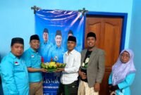 Ketua DPD Partai Gelora Indonesia Pamekasan, Mohammad Saedy Romli bersama pengurus lainnya mengangkat tumpeng sebagai tanda peresmian kantor baru. (ISTIMEWA)