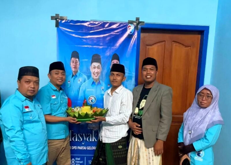Ketua DPD Partai Gelora Indonesia Pamekasan, Mohammad Saedy Romli bersama pengurus lainnya mengangkat tumpeng sebagai tanda peresmian kantor baru. (ISTIMEWA)