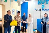 Bupati Pamekasan Dr. KH. Kholilurrahman didampingi Founder Klik Madura, H. Muhammat Mukit menyerahkan santunan sekaligus sembako dari Bani Insan Peduli (BIP) kepada anak yatim. (MOH. IQBALUL KHAVEI MZ / KLIKMADURA)