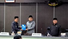 Bupati Pamekasa Dr. KH. Kholilurrahman menyerahkan dokumen jawaban atas PU Fraksi kepada Ketua DPRD Pamekasan, Ali Masykur saat rapat paripurna. (MOH. IQBALUL KHAVEI MZ / KLIKMADURA)