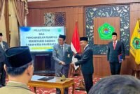 Bupati Pamekasan Dr. KH. Kholilurrahman menyerahkan salinan putusan pengangkatan sekda definitif kepada Taufikurrachman di Peringgitan Dalam, Mandhapa Agung, Ronggosukowati. (MOHAMMAD IQBALUL KHAVEI MZ / KLIKMADURA)