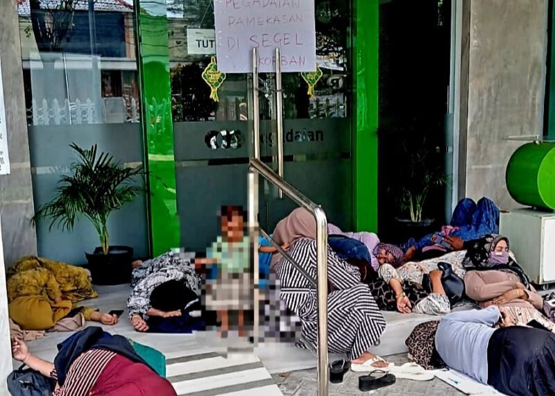 Sejumlah warga yang mengaku korban penipuan agen pegadaian atas nama Hozizah tidur di amperan Kantor PT Pegadaian Syariah Pamekasan, aksi tersebut sebagai bentuk tuntutan agar ada kejelasan ganti rugi. (ISTIMEWA)