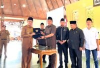 Bupati Pamekasan Dr. KH. Kholilurrahman menyerahkan berkas LKPJ kepada Ketua DPRD Pamekasan, Ali Masykur usia rapat paripurna di Pendopo Agung Ronggosukowati Pamekasan. (MOH. IQBALUL KHAVEI MZ / KLIKMADURA)