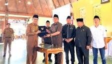 Bupati Pamekasan Dr. KH. Kholilurrahman menyerahkan berkas LKPJ kepada Ketua DPRD Pamekasan, Ali Masykur usia rapat paripurna di Pendopo Agung Ronggosukowati Pamekasan. (MOH. IQBALUL KHAVEI MZ / KLIKMADURA)