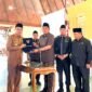 Bupati Pamekasan Dr. KH. Kholilurrahman menyerahkan berkas LKPJ kepada Ketua DPRD Pamekasan, Ali Masykur usia rapat paripurna di Pendopo Agung Ronggosukowati Pamekasan. (MOH. IQBALUL KHAVEI MZ / KLIKMADURA)