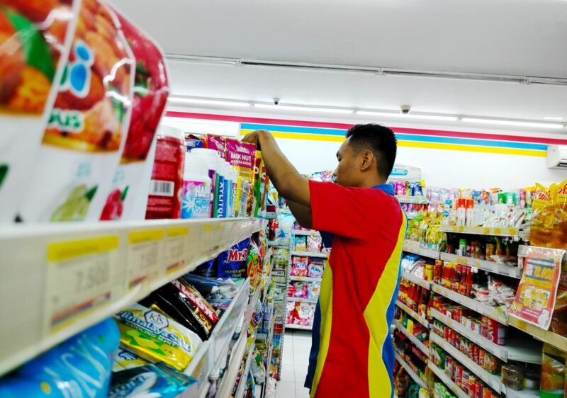 Seorang pekerja toko modern sedang menata barang.  (LAILIYATUN NURIYAH/KLIK MADURA).