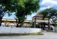 Warga berada di sekitar Pasar Kolpajung yang tampak megah meski masih berpagar seng. (MOHAMMAD IQBALUL KHAVEI MZ / KLIKMADURA)