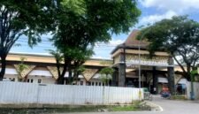 Warga berada di sekitar Pasar Kolpajung yang tampak megah meski masih berpagar seng. (MOHAMMAD IQBALUL KHAVEI MZ / KLIKMADURA)