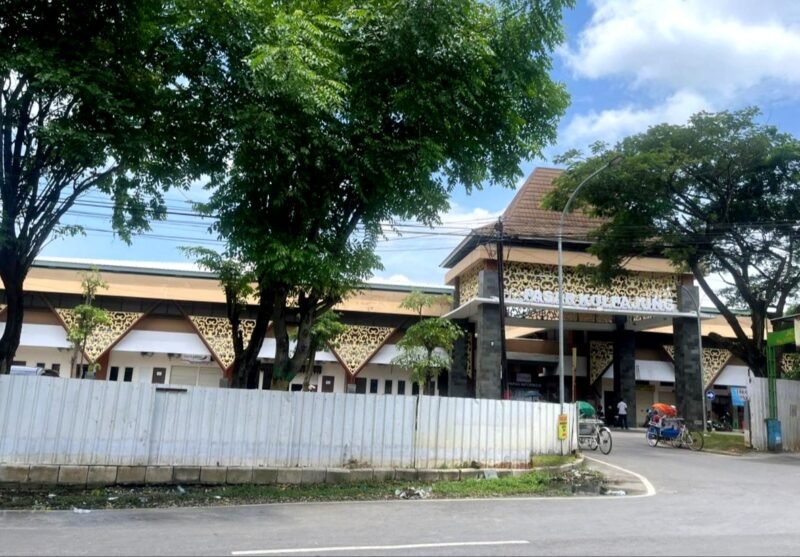 Warga berada di sekitar Pasar Kolpajung yang tampak megah meski masih berpagar seng. (MOHAMMAD IQBALUL KHAVEI MZ / KLIKMADURA)