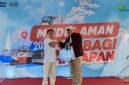 Deputi Bisnis PT. Pegadaian Syariah Area Madura, Anwar Hidayat menyerahkan sembako kepada salah satu peserta mudik gratis. (ISTIMEWA)