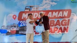 Deputi Bisnis PT. Pegadaian Syariah Area Madura, Anwar Hidayat menyerahkan sembako kepada salah satu peserta mudik gratis. (ISTIMEWA)