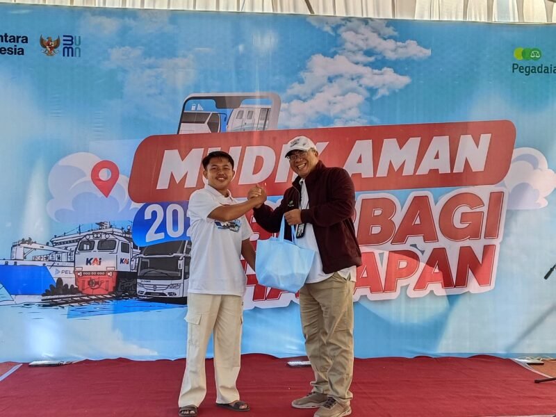 Deputi Bisnis PT. Pegadaian Syariah Area Madura, Anwar Hidayat menyerahkan sembako kepada salah satu peserta mudik gratis. (ISTIMEWA)