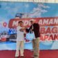 Deputi Bisnis PT. Pegadaian Syariah Area Madura, Anwar Hidayat menyerahkan sembako kepada salah satu peserta mudik gratis. (ISTIMEWA)