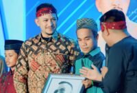 PENUH HARU: Founder BIP Foundation Ali Zainal Abidin menerima lukisan hasil karya Misnaya, warga disabilitas asal Kabupaten Sumenep. (DOK. KLIKMADURA)