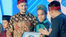 PENUH HARU: Founder BIP Foundation Ali Zainal Abidin menerima lukisan hasil karya Misnaya, warga disabilitas asal Kabupaten Sumenep. (DOK. KLIKMADURA)