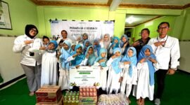 Perwakilan PT. Pegadaian Syariah Kanwil XII Surabaya foto bersama anak yatim usai penyerahan bantuan. (KLIKMADURA)