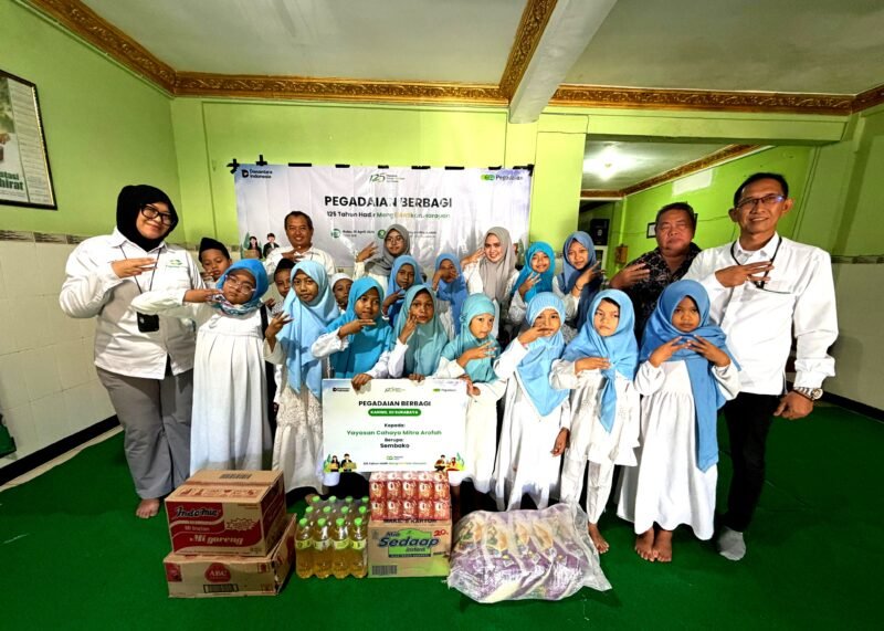 Perwakilan PT. Pegadaian Syariah Kanwil XII Surabaya foto bersama anak yatim usai penyerahan bantuan. (KLIKMADURA)