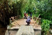 Sejumlah warga berada di jembatan rusak yang dipasangi bambu, tepatnya di Desa Pangorayan, Kecamatan Proppo, Pamekasan. (LAILIYATUN NURIYAH / KLIKMADURA)