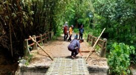 Sejumlah warga berada di jembatan rusak yang dipasangi bambu, tepatnya di Desa Pangorayan, Kecamatan Proppo, Pamekasan. (LAILIYATUN NURIYAH / KLIKMADURA)