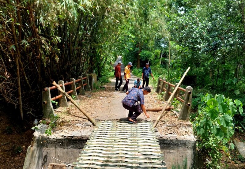 Sejumlah warga berada di jembatan rusak yang dipasangi bambu, tepatnya di Desa Pangorayan, Kecamatan Proppo, Pamekasan. (LAILIYATUN NURIYAH / KLIKMADURA)