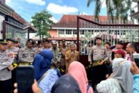 Sekda Pamekasan, Taufikurrachman (pegang mik) saat menemui massa aksi demonstrasi di depan Kantor Bupati Pamekasan. (MOH. IQBALUL KHAVEI MZ / KLIKMADURA)