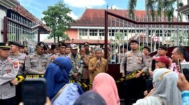 Sekda Pamekasan, Taufikurrachman (pegang mik) saat menemui massa aksi demonstrasi di depan Kantor Bupati Pamekasan. (MOH. IQBALUL KHAVEI MZ / KLIKMADURA)