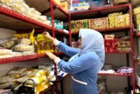 Pedagang di Pasar Kolpajung menata minyak di salah satu kios. (LAILIYATUN NURIYAH / KLIKMADURA)