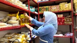 Pedagang di Pasar Kolpajung menata minyak di salah satu kios. (LAILIYATUN NURIYAH / KLIKMADURA)