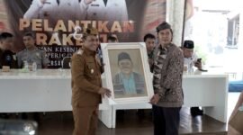 Ketua DKP Pamekasan, Arief Wibisono menyerahkan lukisan kepada Wabup Pamekasan H. Sukriyanto usai pelantikan. (LAILIYATUN NURIYAH / KLIKMADURA)